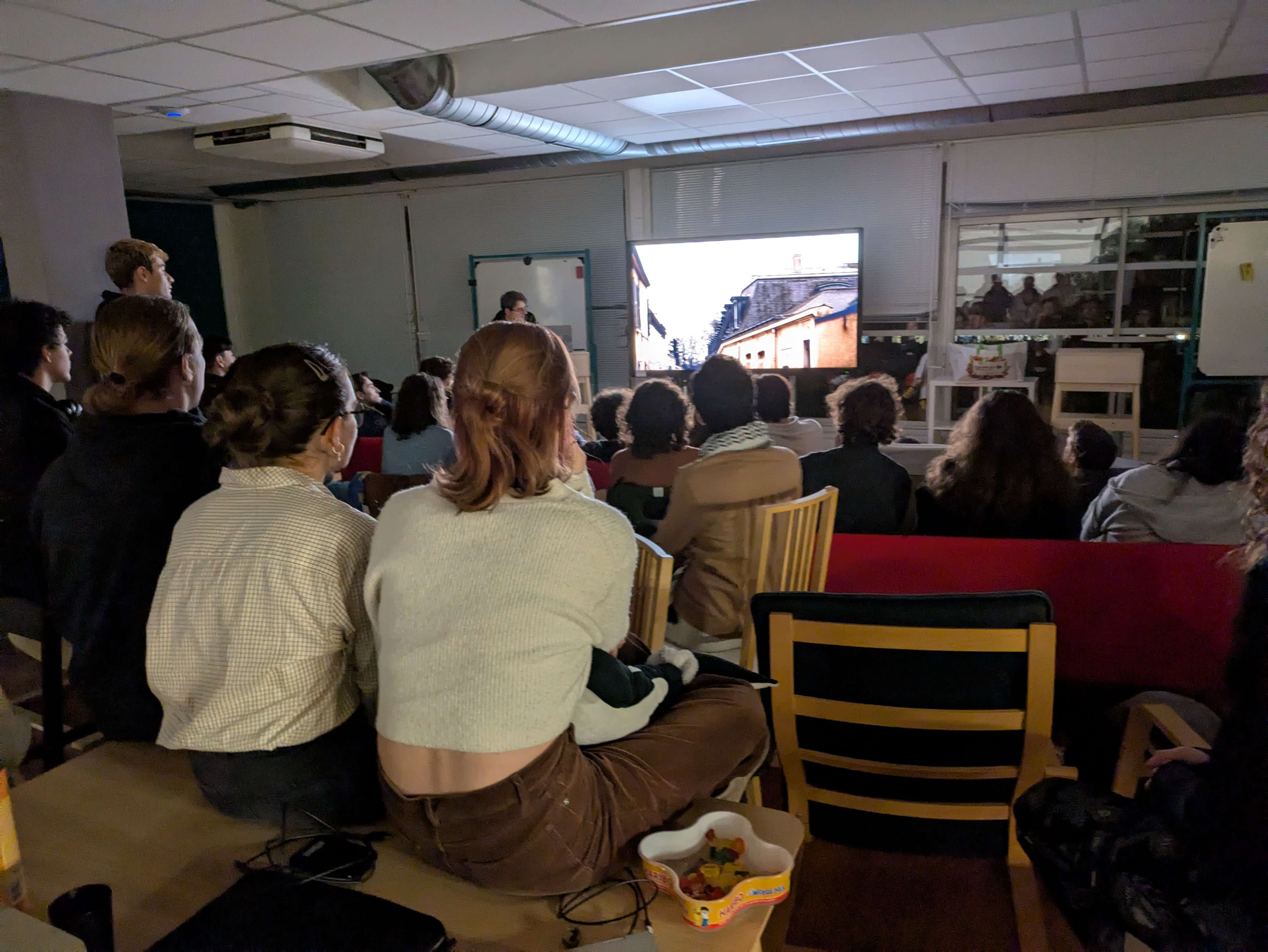 Des participants regardent un film dans une salle de projection